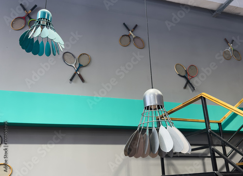 A collection of vintage wooden tennis rackets hang on a wall, their strings  photo