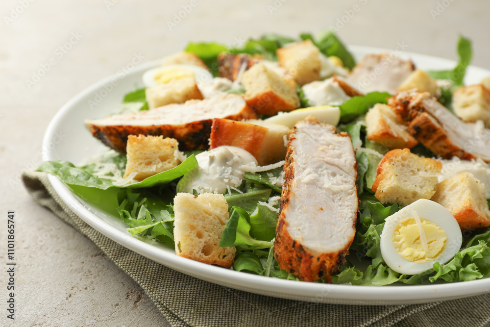 Tasty Caesar salad with chicken on light grey table, closeup Tasty Caesar salad with chicken on light grey table, closeup