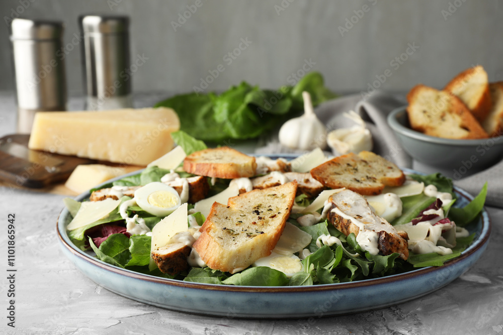Tasty Caesar salad with chicken on gray textured table, closeup Tasty Caesar salad with chicken on gray textured table, closeup