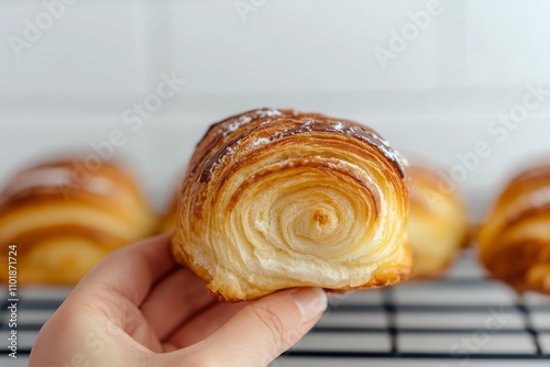 Delicious chocolate croissant in hand showing flaky pastry and rich filling a...