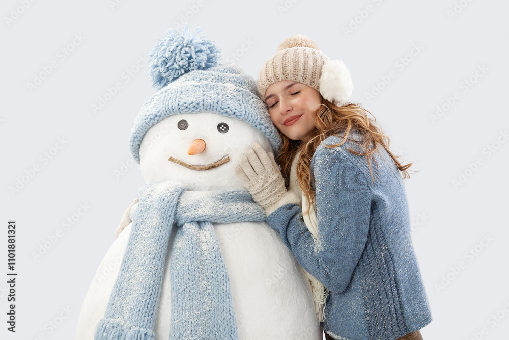 Happy young woman enjoying embracing a snowman dressed in warm winter clothing, hat and scarf knitted. Ski trip during the Christmas holidays in winter season. Cooling and Heating temperatures concept Happy young woman enjoying embracing a snowman dressed in warm winter clothing, hat and scarf knitted. Ski trip during the Christmas holidays in winter season. Cooling and Heating temperatures concept