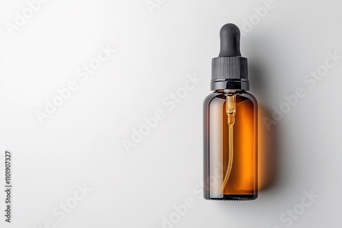 Amber glass dropper bottle on white surface