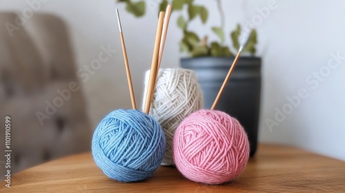 Yarn balls and knitting needles rest on a wooden surface