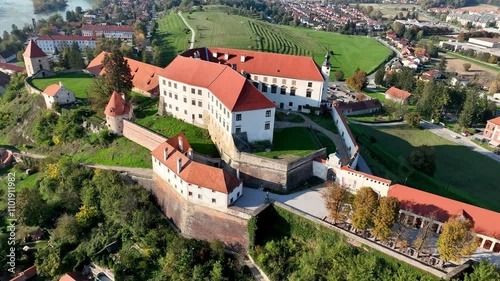 Aerial video with beautiful Ptuj castle on a hilltop above houses of Ptuj old town along Drava river in Slovenia