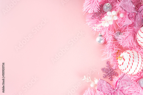 Kitschmas Christmas background with fluffy pink artificial Christmas tree brunches, pink festive bow and decorations in trendy embracing kitsch style, top view flat lay copy space photo