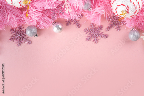 Kitschmas Christmas background with fluffy pink artificial Christmas tree brunches, pink festive bow and decorations in trendy embracing kitsch style, top view flat lay copy space photo