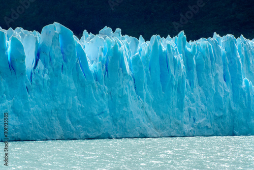 Perito Moreno glacier front in Patagonia with crystalline blue ice formations contrasting with the icy grey water of the lake