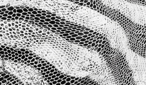 Faux leather pattern resembling snakeskin. Featuring lines and spots structural texture. Modern, abstract illustration with a cool, artsy background. Black design, isolated on white. EPS10