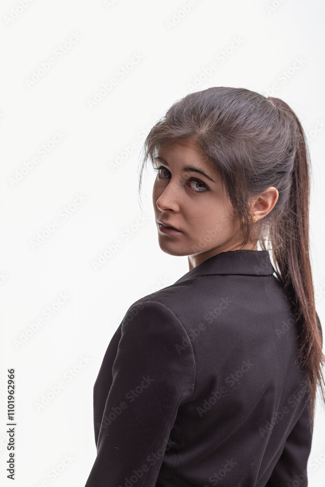 Young businesswoman looking back over shoulder with pensive expr Young businesswoman looking back over shoulder with pensive expr
