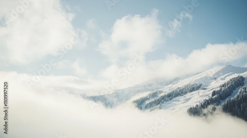 Snowy mountain peaks shrouded in mist under a bright sky.