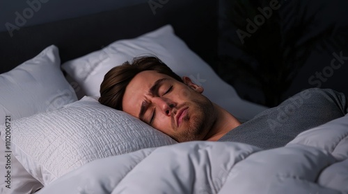 A peaceful man sleeping soundly under cozy blankets at night.