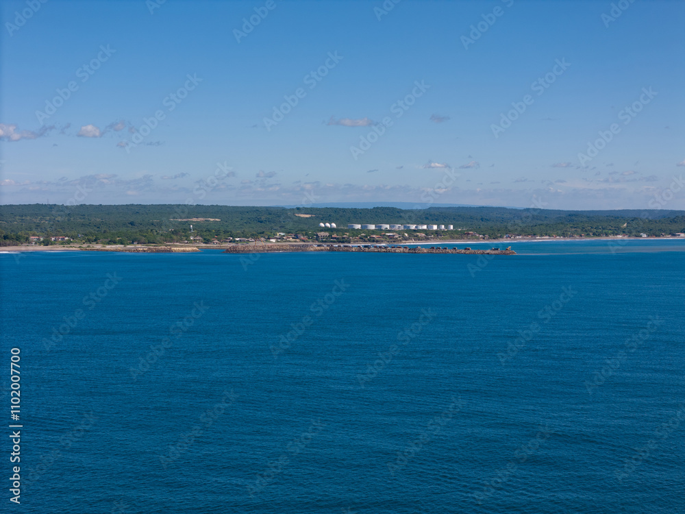 Coastal view of serene shoreline under clear blue sky in tranquil setting
