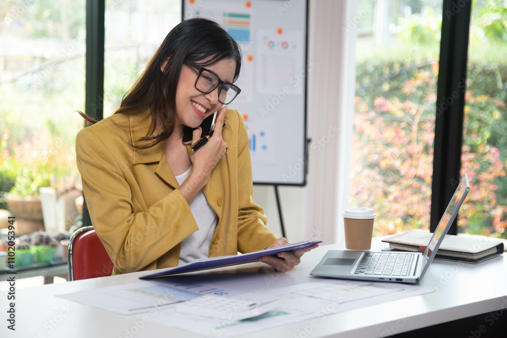 Businesswoman holding a phone talking about a housing development project Businesswoman holding a phone talking about a housing development project