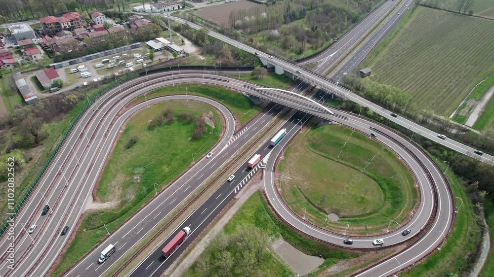 The European highways and road infrastructure, captured with drone footage showcasing the flow of traffic from above. The European highways and road infrastructure, captured with drone footage showcasing the flow of traffic from above.
