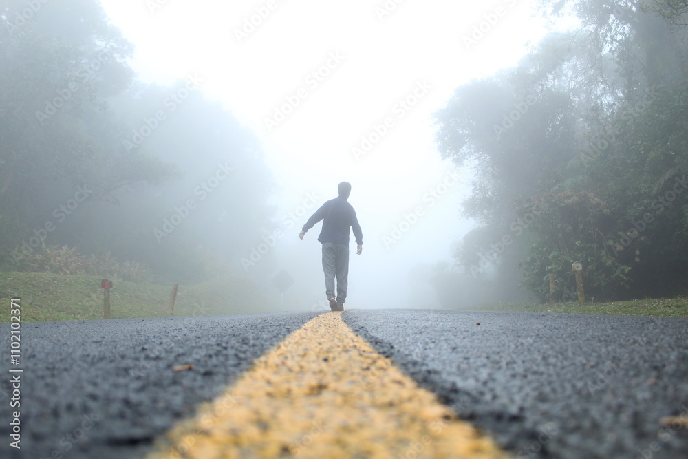 silhueta de homem caminhando em estrada com neblina - na estrada da graciosa, paraná silhueta de homem caminhando em estrada com neblina - na estrada da graciosa, paraná