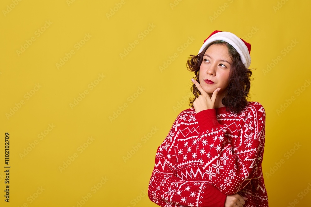 Thoughtful young woman wearing a Santa hat and Christmas sweater looking away Thoughtful young woman wearing a Santa hat and Christmas sweater looking away