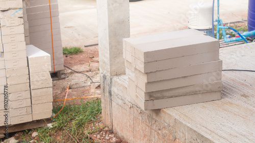 A pile of lightweight bricks that are stacked on top of each other separated from the larger pile. Inside the construction site