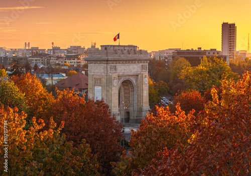 Arch of Triumph in Bucharest, visit Romania. Aerial photo with Arch of Triumph historical landmark in Bucharest during a beautiful autumn sunset. Concept image for Romania.