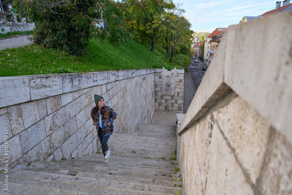 A woman smiling as she climbs a staircase, excited to explore the city, with her face radiating happiness A woman smiling as she climbs a staircase, excited to explore the city, with her face radiating happiness