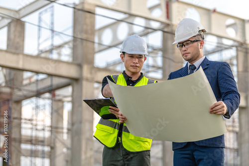 A team of engineers consults and plans the construction of the building. The architect, supervisor, and foreman meet to discuss the design of the building,working at site of a large building project