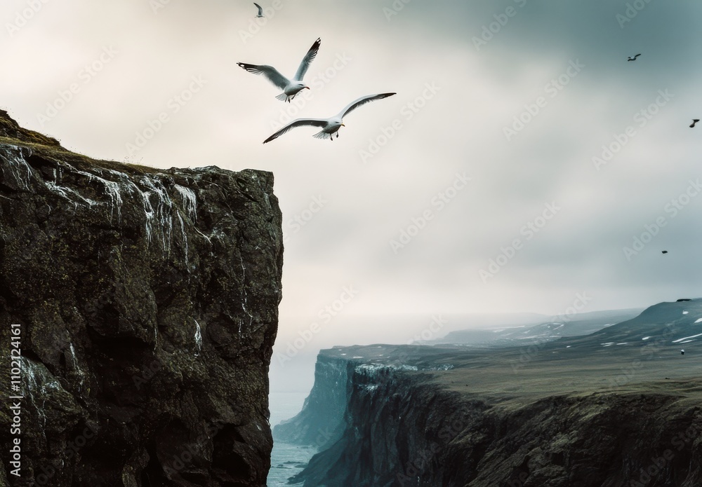 Fototapeta premium Majestic Seagulls Flying Above a Rugged Cliff with Dramatic Sky and Coastal Landscape in the Background, Capturing the Beauty of Nature's Wilderness