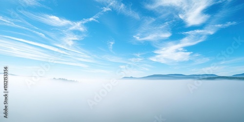 A soft blanket of fog envelops the lake and its surroundings in the early morning hours revealing a breathtaking blue sky with wispy clouds, cloud formations, natural beauty, misty weather