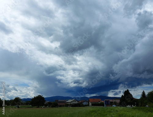 Obraz na płótnie dark gray clouds over houses. Slovenia. Sky before storm w salonie