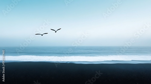 A minimalist shot of a single bird flying above a vast black sand beach with a clear blue sky