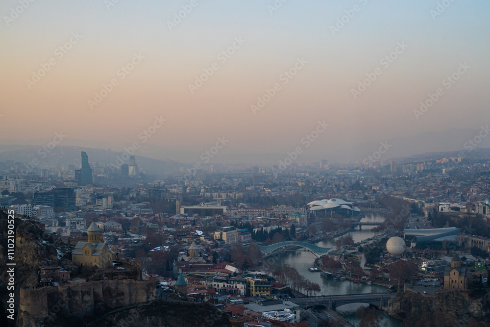 A tranquil winter evening envelops Tbilisi, as soft hues blanket the city skyline. A tranquil winter evening envelops Tbilisi, as soft hues blanket the city skyline.