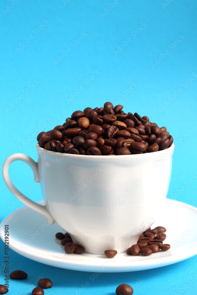 A cup with coffee beans stands on a blue background. A cup with coffee beans stands on a blue background.