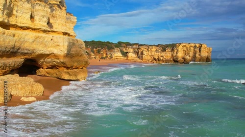 Beautiful sea with waves on the rocky coast of Algarve in Portugal