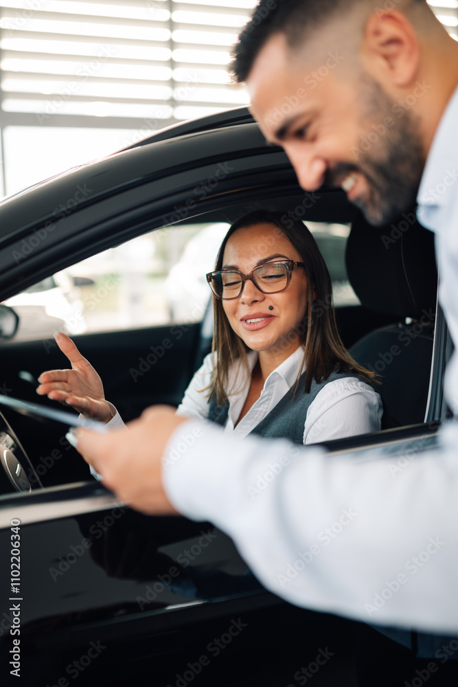 Woman discussing in car with a salesman in a car dealership Woman discussing in car with a salesman in a car dealership
