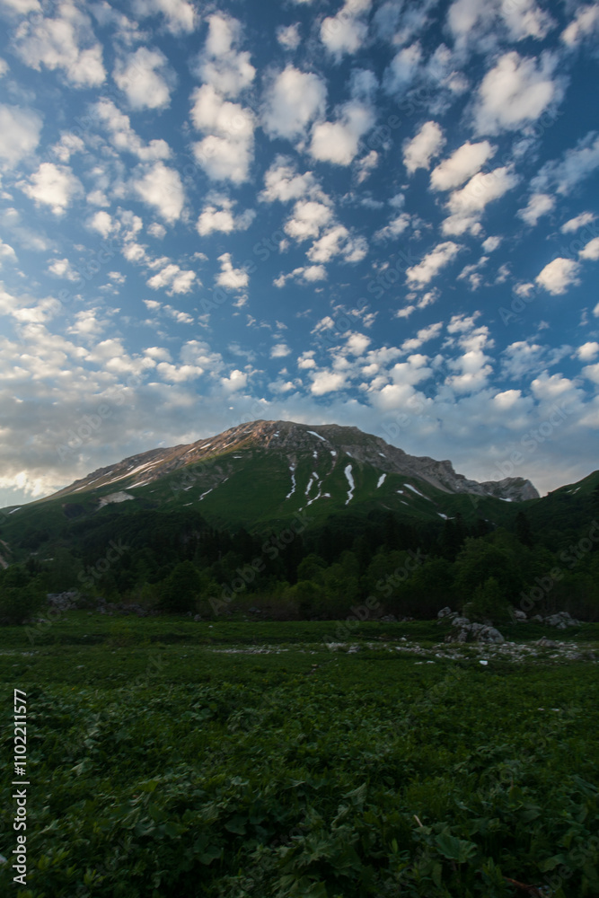 A picturesque view of Fishtail Mountain, showcasing its snow-capped peak and lush greenery against a backdrop of a blue sky dotted with fluffy white clouds. A picturesque view of Fishtail Mountain, showcasing its snow-capped peak and lush greenery against a backdrop of a blue sky dotted with fluffy white clouds.