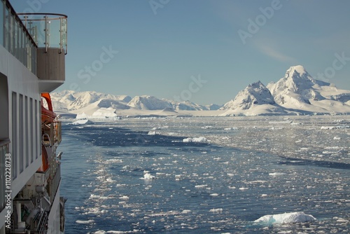 A remote, untouched corner of Antarctica, where the land is a canvas of snow and ice. The stillness of the icy landscape is broken only by the occasional silhouette of a distant iceberg.