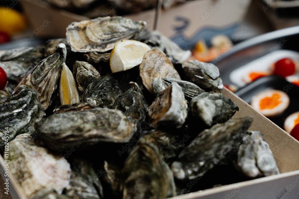 Fresh oysters with lemon served at a seafood market in the afternoon Fresh oysters with lemon served at a seafood market in the afternoon