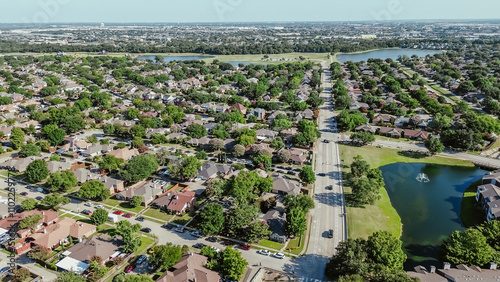 Street parade at lakeside residential neighborhood in Coppell suburbs Dallas, Texas, tree lined residential street, row of single-family houses, swimming pool, fast growing housing market, aerial photo
