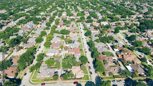 Parallel tree lined residential streets with row of large single-family houses, fenced backyard, swimming pool in upscale Coppell suburbs Dallas, Texas, fast growing housing market, aerial view photo