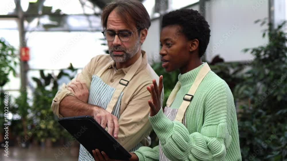 Colleagues Discuss Strategy in a Greenhouse Setting Colleagues Discuss Strategy in a Greenhouse Setting