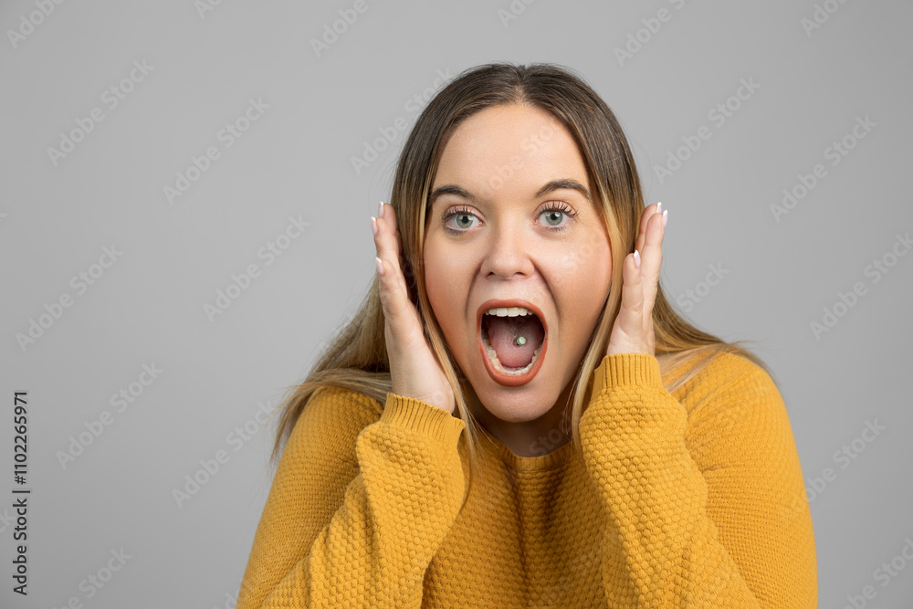 Woman in yellow showing shock, hands on her face in astonishment Woman in yellow showing shock, hands on her face in astonishment