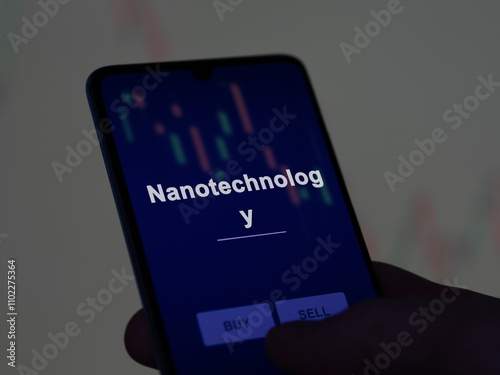 An investor analyzing the nanotechnology etf fund on a screen. A phone shows the prices of Nanotechnology photo