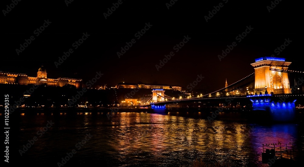 Wide night panorama of a royal palace in Budapeszt with the illuminated Széchenyi Chain Bridge in the foreground. Wide night panorama of a royal palace in Budapeszt with the illuminated Széchenyi Chain Bridge in the foreground.