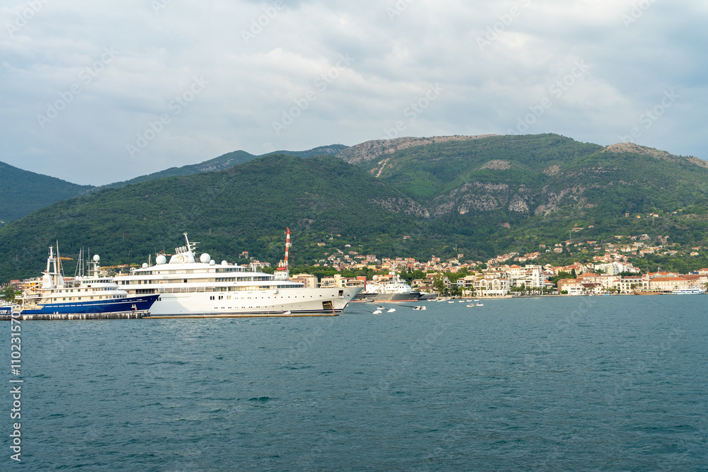 View of port in city Tivat, Montenegro. Port crane, yachts and pleasure boats at pier in the Balkans. Boat trips on Adriatic Sea View of port in city Tivat, Montenegro. Port crane, yachts and pleasure boats at pier in the Balkans. Boat trips on Adriatic Sea