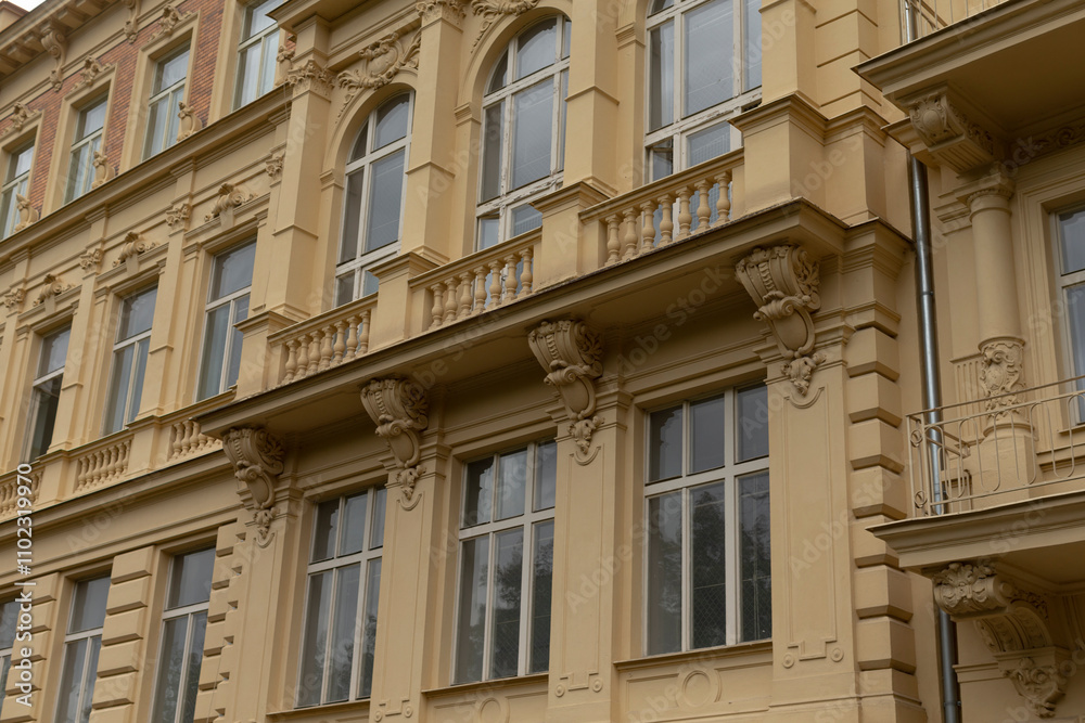 A large and impressive building that features a significant number of windows, along with numerous balconies for outdoor spaces A large and impressive building that features a significant number of windows, along with numerous balconies for outdoor spaces