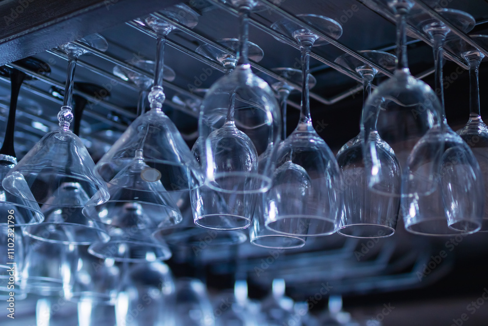 A collection of wine glasses elegantly hanging from a display rack A collection of wine glasses elegantly hanging from a display rack