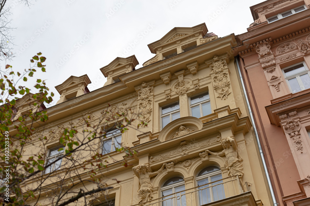 There is a large building that showcases numerous windows, and situated right in front of it is a beautiful tree providing shade There is a large building that showcases numerous windows, and situated right in front of it is a beautiful tree providing shade