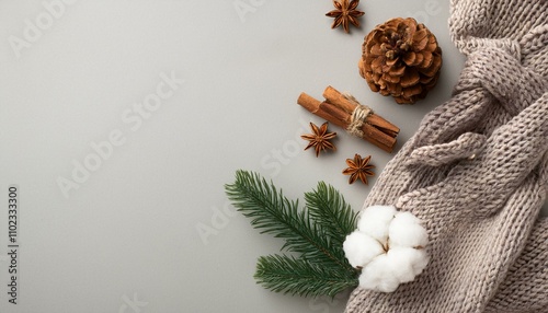 Winter season concept. Top view photo of knitted scarf  cinnamon sticks pine cone photo