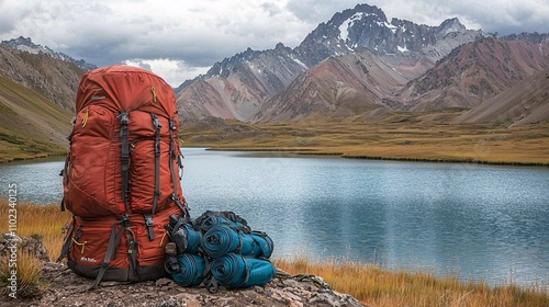 a bag pack set on a mountain ridge and lake Saif ul Maloo is visibal in the background some of the traveling equipment is set with the bagpack photo