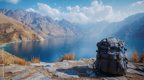 a bag pack set on a mountain ridge and lake Saif ul Maloo is visibal in the background some of the traveling equipment is set with the bagpack photo