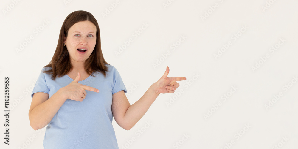 Hey look. Smiling pretty female model pointing fingers right at empty space and inviting to check it out, showing advertisement on white background. Hey look. Smiling pretty female model pointing fingers right at empty space and inviting to check it out, showing advertisement on white background.