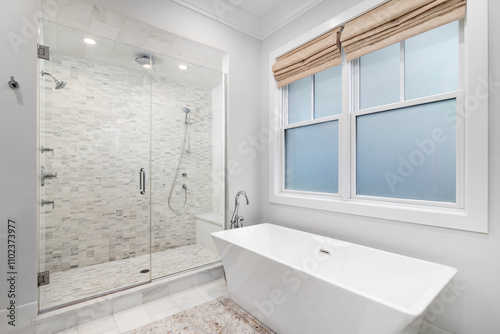 A bathroom detail with a freestanding bathtub with a chrome faucet and a large shower with small rectangle marble tiles, a bench seat, and chrome faucets. photo